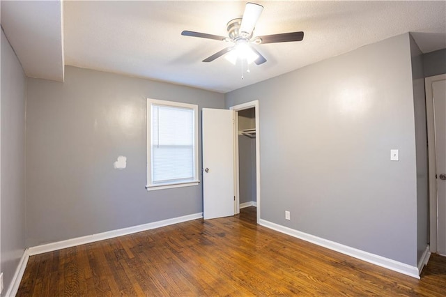 9904 E 60th Ter, Raytown, MO 64133 - unfurnished bedroom featuring wood finished floors, a closet, baseboards, and a ceiling fan