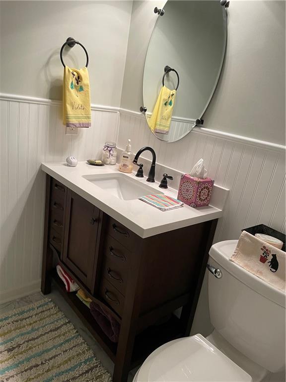 4413 E 107th St, Kansas City, MO 64137 - half bath featuring vanity and wainscoting