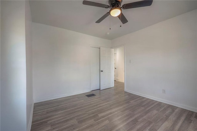1607 E 37th St, Kansas City, MO 64109 - spare room featuring wood finished floors, baseboards, and ceiling fan