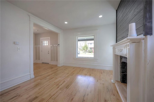 1607 E 37th St, Kansas City, MO 64109 - unfurnished living room featuring wood finished floors, plenty of natural light, baseboards, a premium fireplace, and recessed lighting