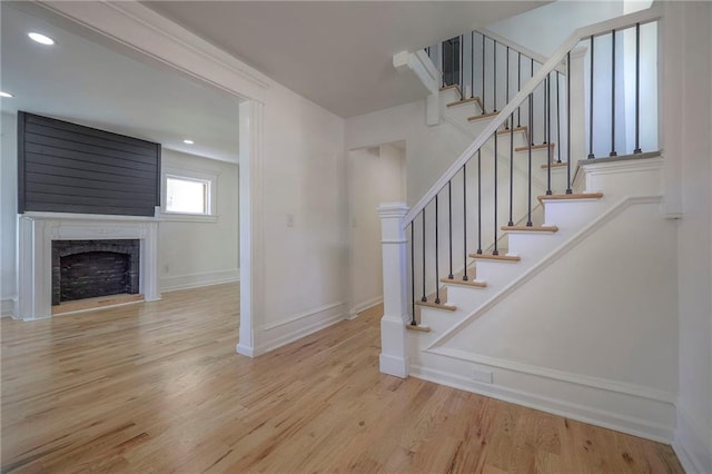 1607 E 37th St, Kansas City, MO 64109 - staircase with wood finished floors, baseboards, a fireplace, and recessed lighting