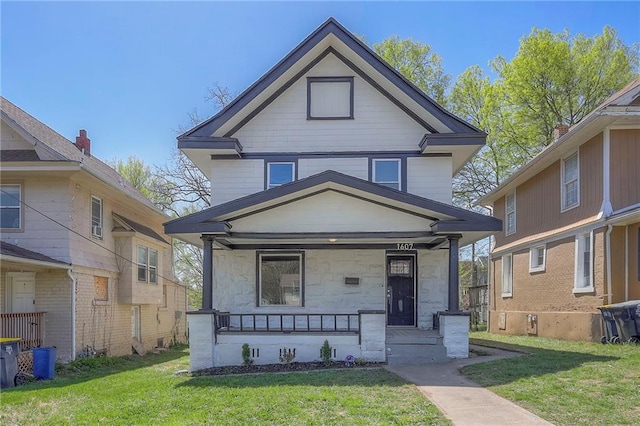 1607 E 37th St, Kansas City, MO 64109 - american foursquare style home featuring covered porch, a front lawn, and stone siding