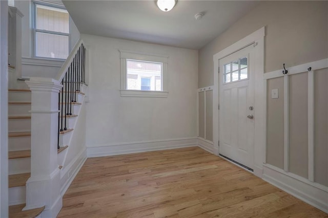 1607 E 37th St, Kansas City, MO 64109 - foyer entrance with healthy amount of natural light, light wood finished floors, stairs, and baseboards