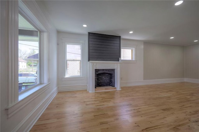 1607 E 37th St, Kansas City, MO 64109 - unfurnished living room with a high end fireplace, light wood-type flooring, baseboards, and recessed lighting