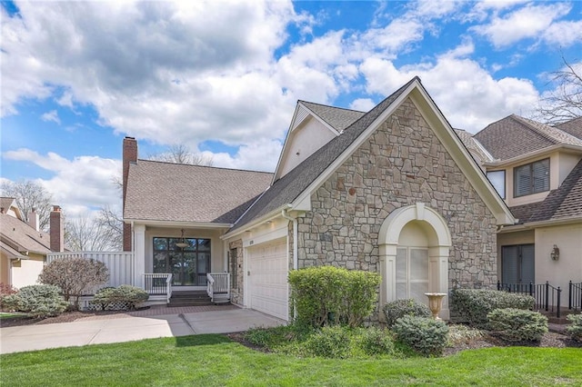 view of front of house featuring an attached garage, concrete driveway, a shingled roof, and stone siding