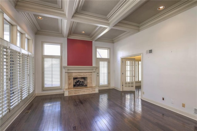 unfurnished living room with plenty of natural light, a tiled fireplace, and baseboards