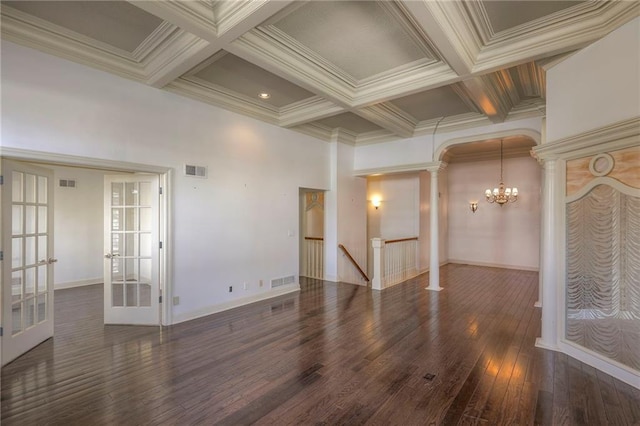 unfurnished living room with an inviting chandelier, visible vents, coffered ceiling, decorative columns, and wood-type flooring