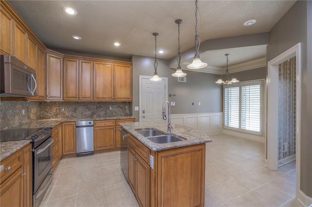 kitchen featuring a sink, brown cabinets, appliances with stainless steel finishes, and tasteful backsplash