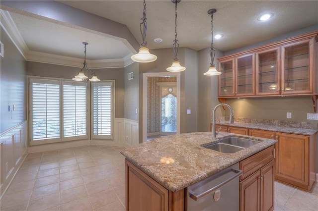 kitchen featuring decorative light fixtures, a sink, a decorative wall, brown cabinets, and stainless steel dishwasher