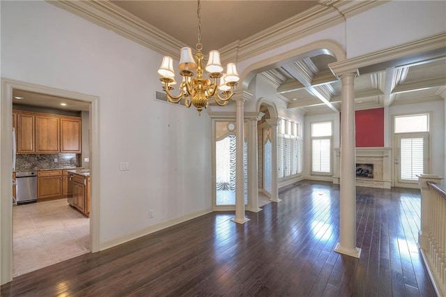 unfurnished living room featuring a notable chandelier, light wood-style floors, crown molding, ornate columns, and coffered ceiling