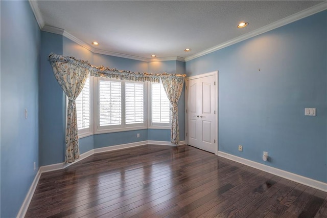 spare room with wood-type flooring, ornamental molding, and baseboards