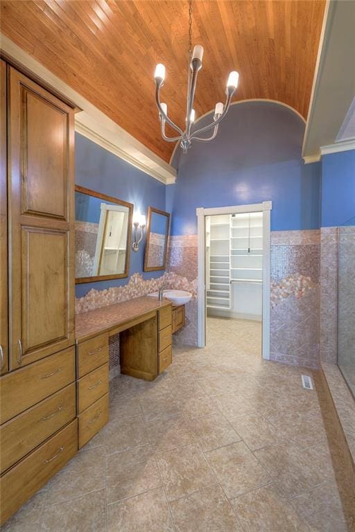 bathroom with an inviting chandelier, wood ceiling, vanity, a wainscoted wall, and lofted ceiling
