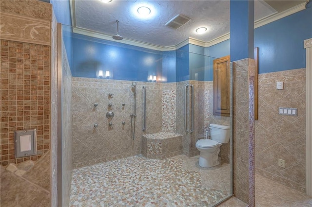 full bath featuring crown molding, tile walls, a tile shower, toilet, and visible vents