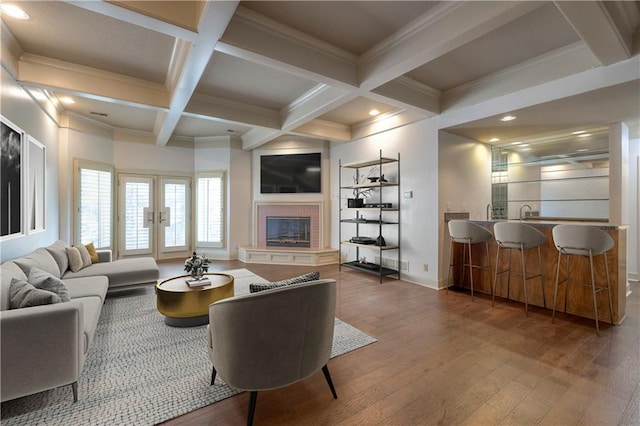 living room with beamed ceiling, baseboards, hardwood / wood-style flooring, and coffered ceiling