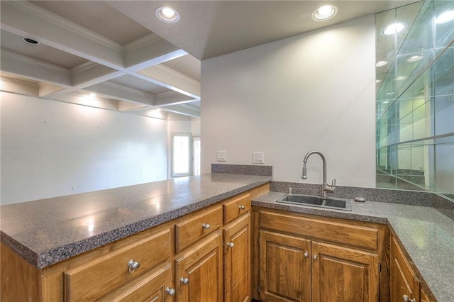 kitchen featuring a sink, brown cabinetry, and dark countertops
