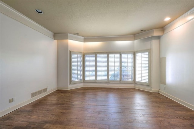 unfurnished room featuring crown molding, a textured ceiling, wood-type flooring, baseboards, and visible vents