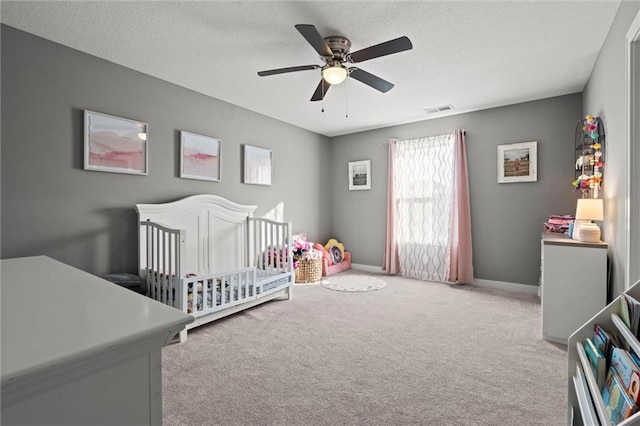 4513 NE Parks Summit Ter, Lees Summit, MO 64064 - carpeted bedroom featuring visible vents, baseboards, a ceiling fan, and a crib