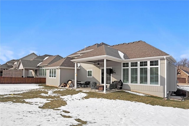 4513 NE Parks Summit Ter, Lees Summit, MO 64064 - snow covered back of property featuring a shingled roof, fence, a ceiling fan, and a patio