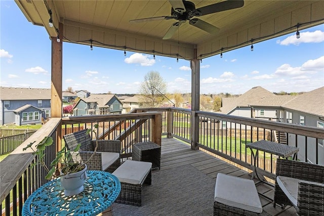 wooden terrace featuring a ceiling fan and a residential view