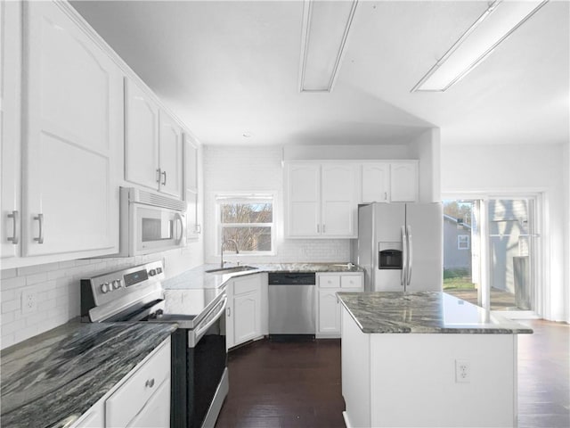 12207 N Pomona Ave, Kansas City, MO 64163 - kitchen featuring stainless steel appliances, dark wood-type flooring, a sink, and dark stone counters