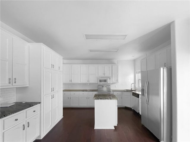12207 N Pomona Ave, Kansas City, MO 64163 - kitchen with white cabinetry, a kitchen island, a sink, stainless steel appliances, and dark wood-style floors