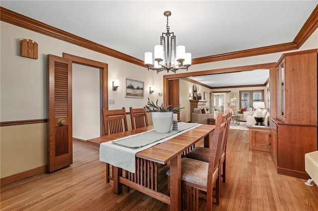 6721 Santa Fe Dr, Overland Park, KS 66204 - dining room with crown molding, baseboards, a notable chandelier, and light wood-style floors