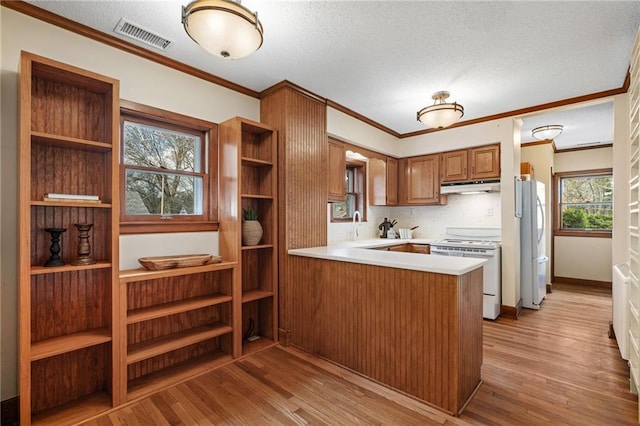 6721 Santa Fe Dr, Overland Park, KS 66204 - kitchen featuring ornamental molding, white appliances, light countertops, under cabinet range hood, and visible vents