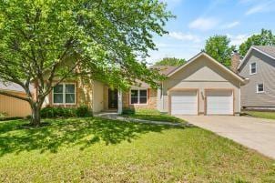 11930 Charlotte St, Kansas City, MO 64146 - view of front of house with driveway, an attached garage, and a front lawn