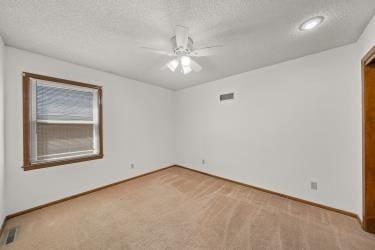 11930 Charlotte St, Kansas City, MO 64146 - spare room with carpet flooring, ceiling fan, baseboards, and a textured ceiling