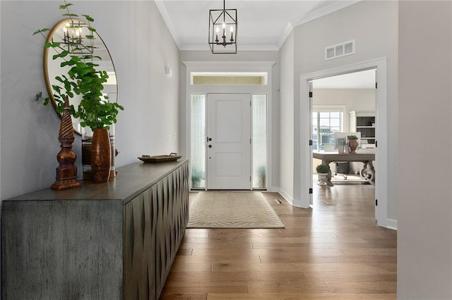 6604 NW 107th Ct, Kansas City, MO 64154 - entrance foyer featuring visible vents, baseboards, a notable chandelier, ornamental molding, and wood-type flooring