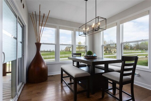 6604 NW 107th Ct, Kansas City, MO 64154 - dining area featuring visible vents, dark wood-style flooring, baseboards, and an inviting chandelier
