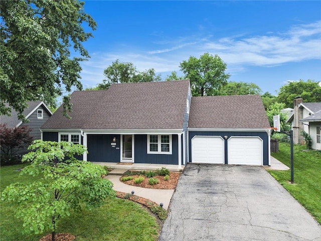 3600 W 48th St, Roeland Park, KS 66205 - view of front facade featuring a garage, asphalt driveway, covered porch, a front yard, and a shingled roof