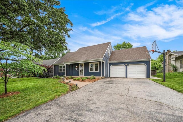3600 W 48th St, Roeland Park, KS 66205 - view of front facade with board and batten siding, a garage, asphalt driveway, a front yard, and roof with shingles