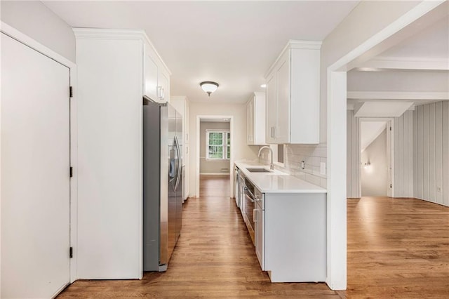 3600 W 48th St, Roeland Park, KS 66205 - kitchen featuring stainless steel fridge with ice dispenser, light countertops, light wood finished floors, a sink, and white cabinetry