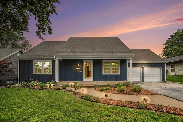 3600 W 48th St, Roeland Park, KS 66205 - view of front of home featuring board and batten siding, covered porch, a garage, driveway, and a front lawn