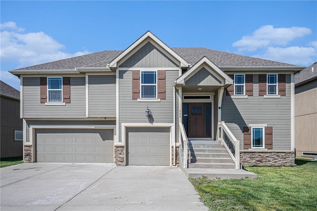 raised ranch with a garage, a front yard, and driveway