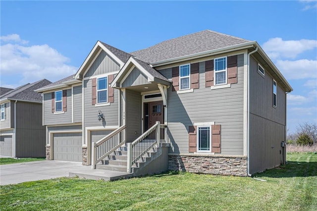 split foyer home with an attached garage, driveway, a front yard, and stone siding