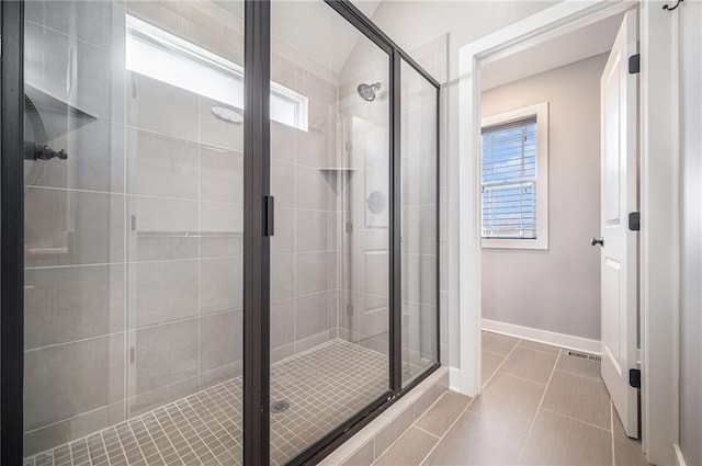 full bathroom featuring a shower stall, tile patterned floors, and baseboards
