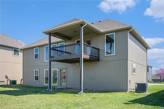back of property featuring a yard, a shingled roof, and central AC