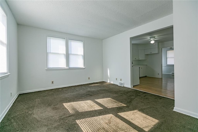 6936 Kensington Ave, Kansas City, MO 64132 - unfurnished living room featuring carpet flooring, a textured ceiling, ceiling fan, and baseboards