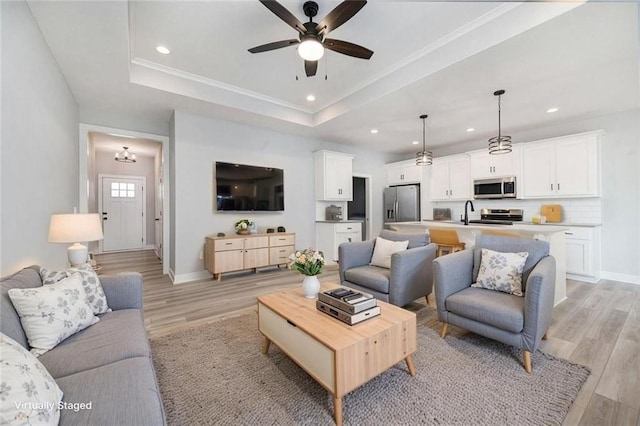 19703 W 196th St, Spring Hill, KS 66083 - living room featuring a tray ceiling, light wood-style floors, a ceiling fan, recessed lighting, and ornamental molding