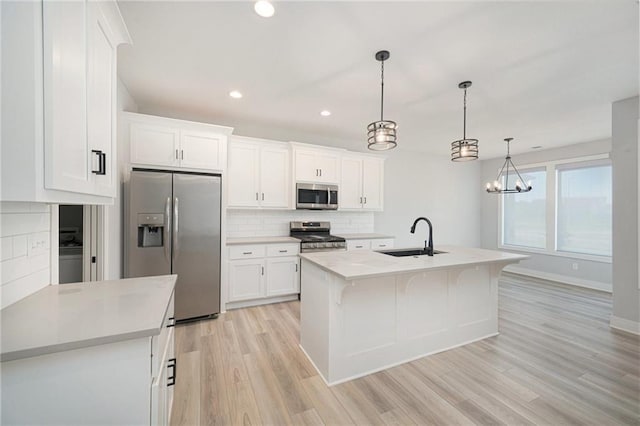19703 W 196th St, Spring Hill, KS 66083 - kitchen with appliances with stainless steel finishes, decorative backsplash, light countertops, light wood finished floors, and recessed lighting