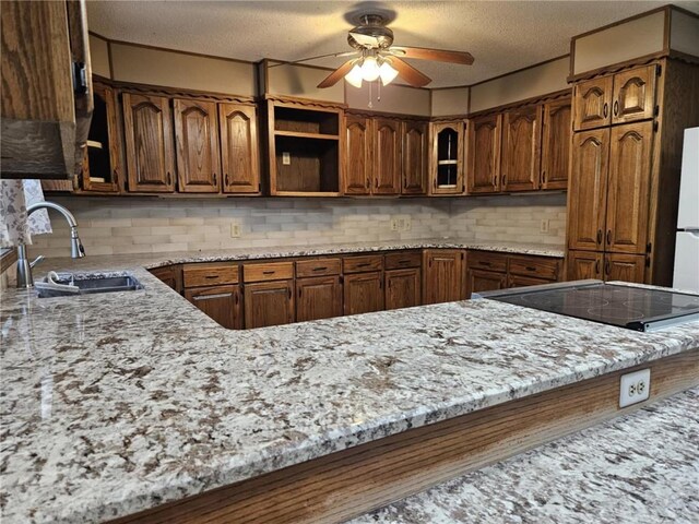 415 N Western St, Girard, KS 66762 - kitchen with tasteful backsplash, light stone counters, a textured ceiling, a ceiling fan, and a sink