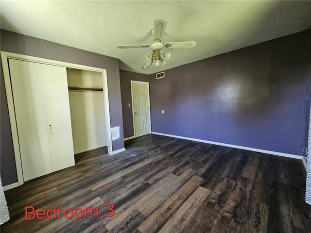 415 N Western St, Girard, KS 66762 - unfurnished bedroom with visible vents, baseboards, a closet, a ceiling fan, and wood finished floors