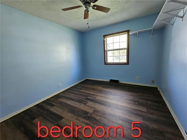 415 N Western St, Girard, KS 66762 - empty room featuring a textured ceiling, wood finished floors, ceiling fan, and baseboards