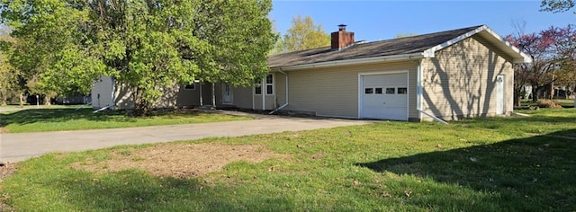 415 N Western St, Girard, KS 66762 - view of front of house with concrete driveway, a front lawn, a chimney, and an attached garage