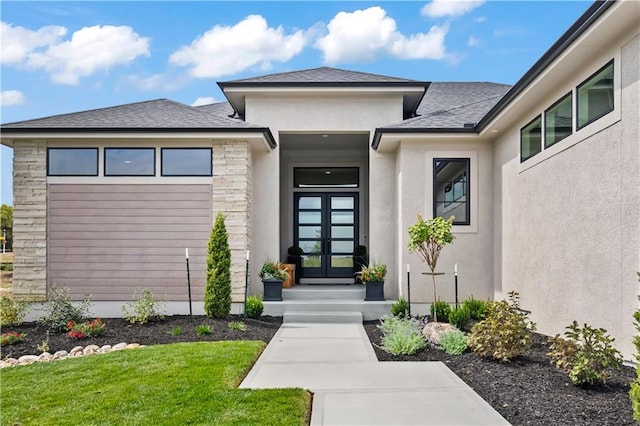 view of exterior entry with roof with shingles, french doors, stone siding, and stucco siding