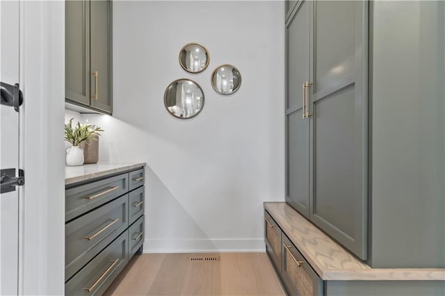 mudroom featuring baseboards and light wood-style floors