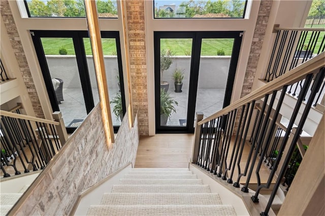 staircase featuring a high ceiling and wood finished floors