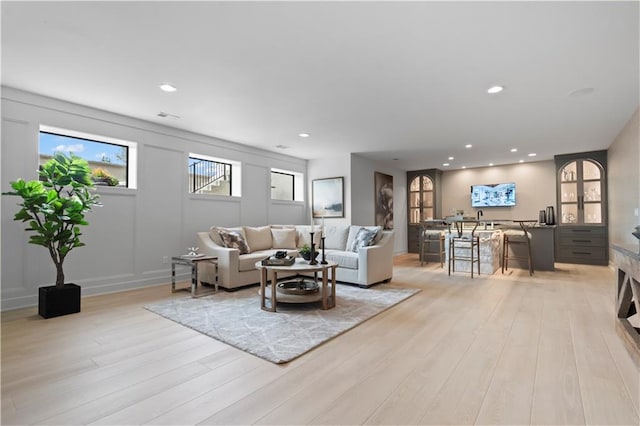 living room with light wood-style flooring and recessed lighting